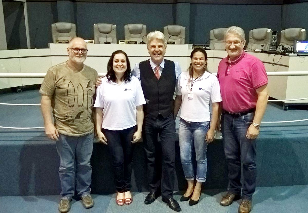 Palestrante entre dirigentes e equipe da entidade